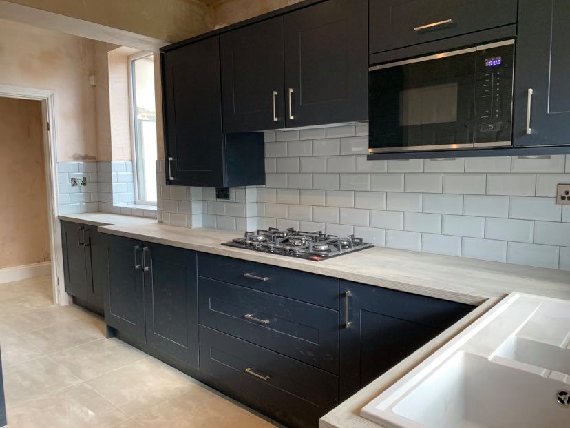 modern kitchen with blue shaker cupboard doors and grey worktops