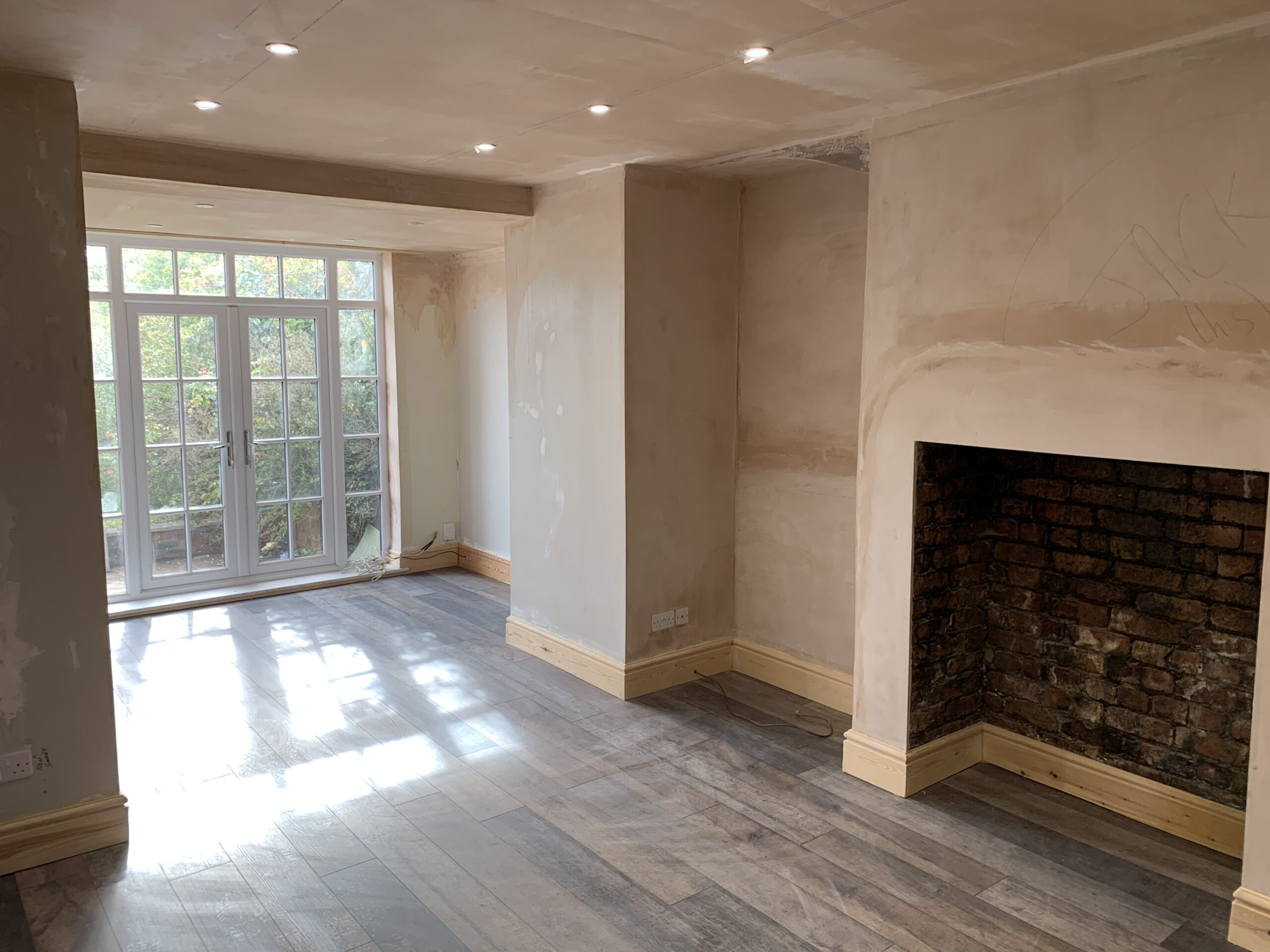 freshly plastered living room with new skirting boards and hardwood flooring