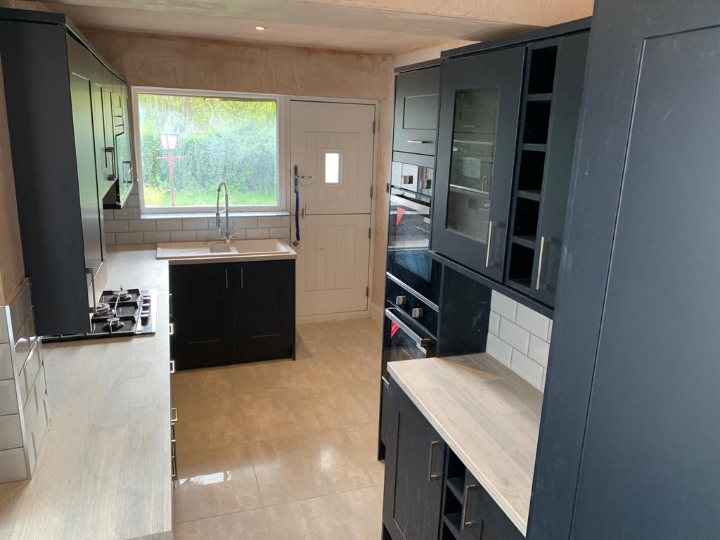 Modern blue kitchen with shaker cupboard doors and grey worktops