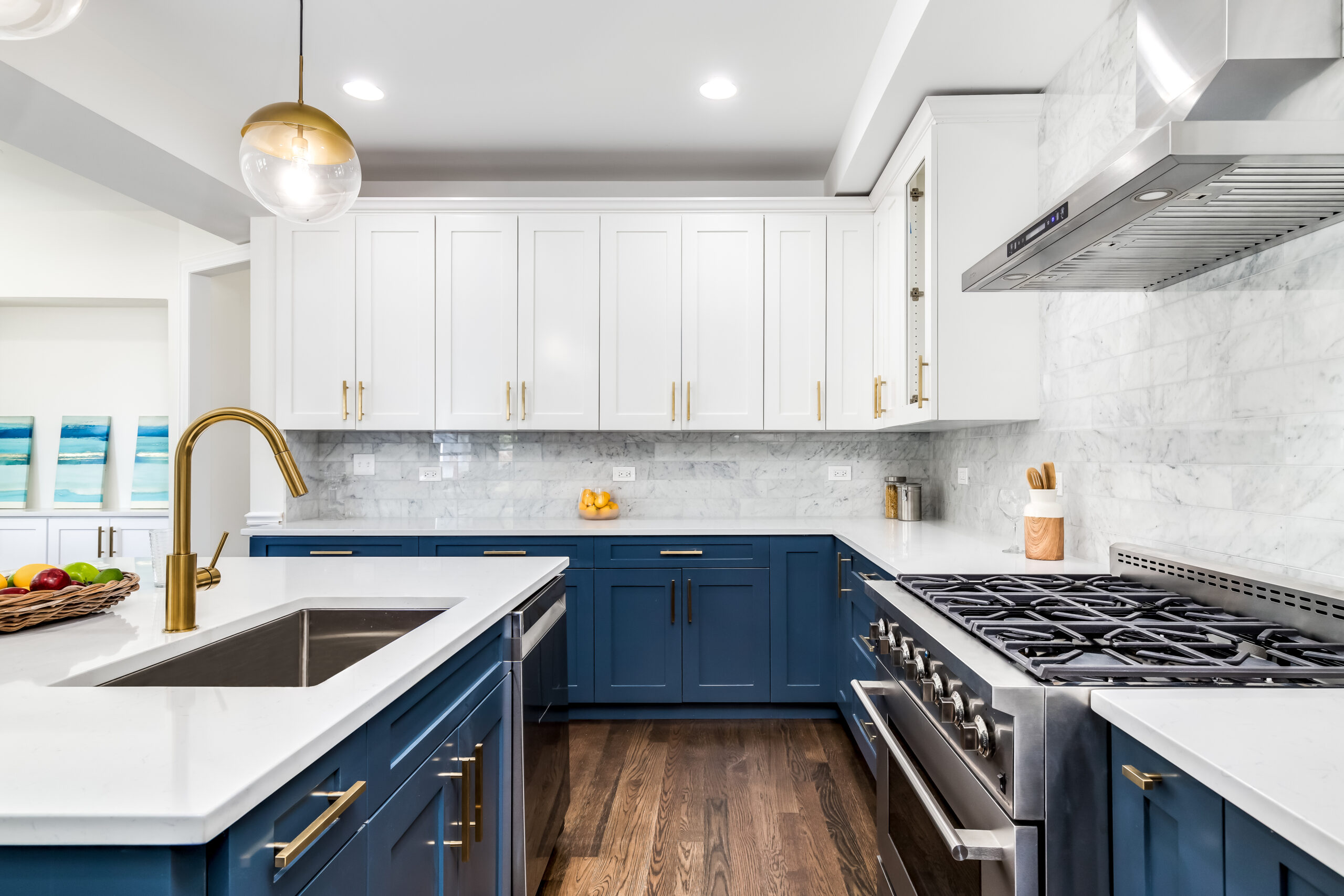 Modern kitchen with blue base units, white wall cabinets and brass taps