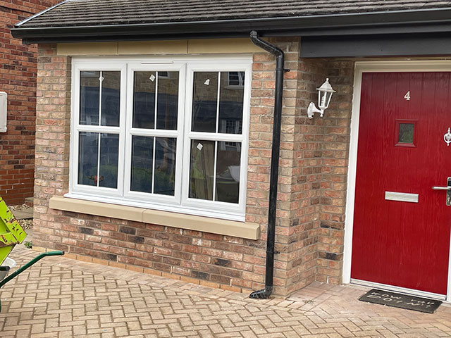 https://signaturehomeimprovements.uk/wp-content/uploads/2025/01/Garage-conversion-with-stone-lintels-and-red-front-door.jpg
