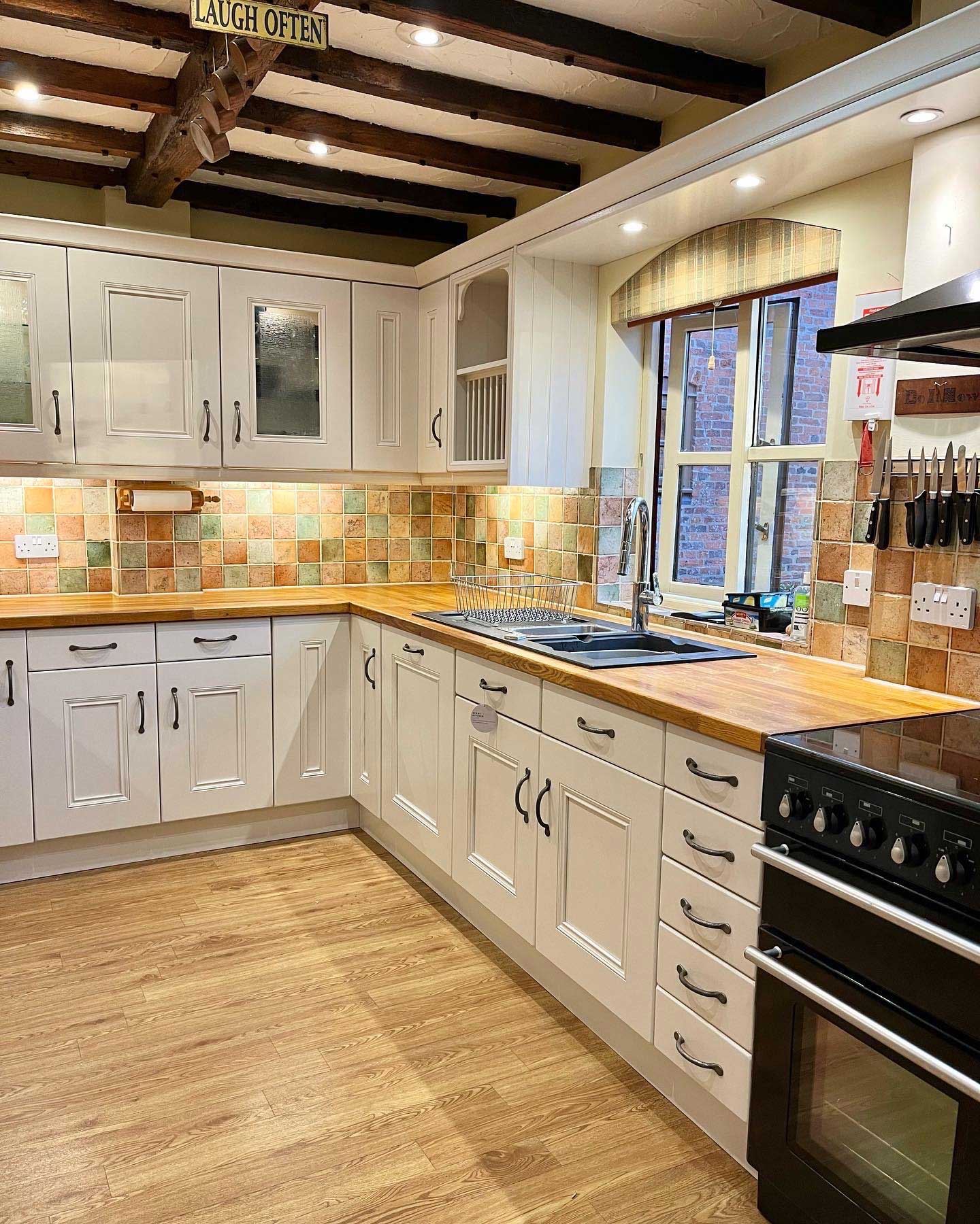 cream kitchen with oak floors and oak worktop