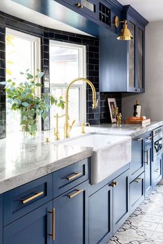 navy kitchen with stone worktops, belfast sink and antique brass handles