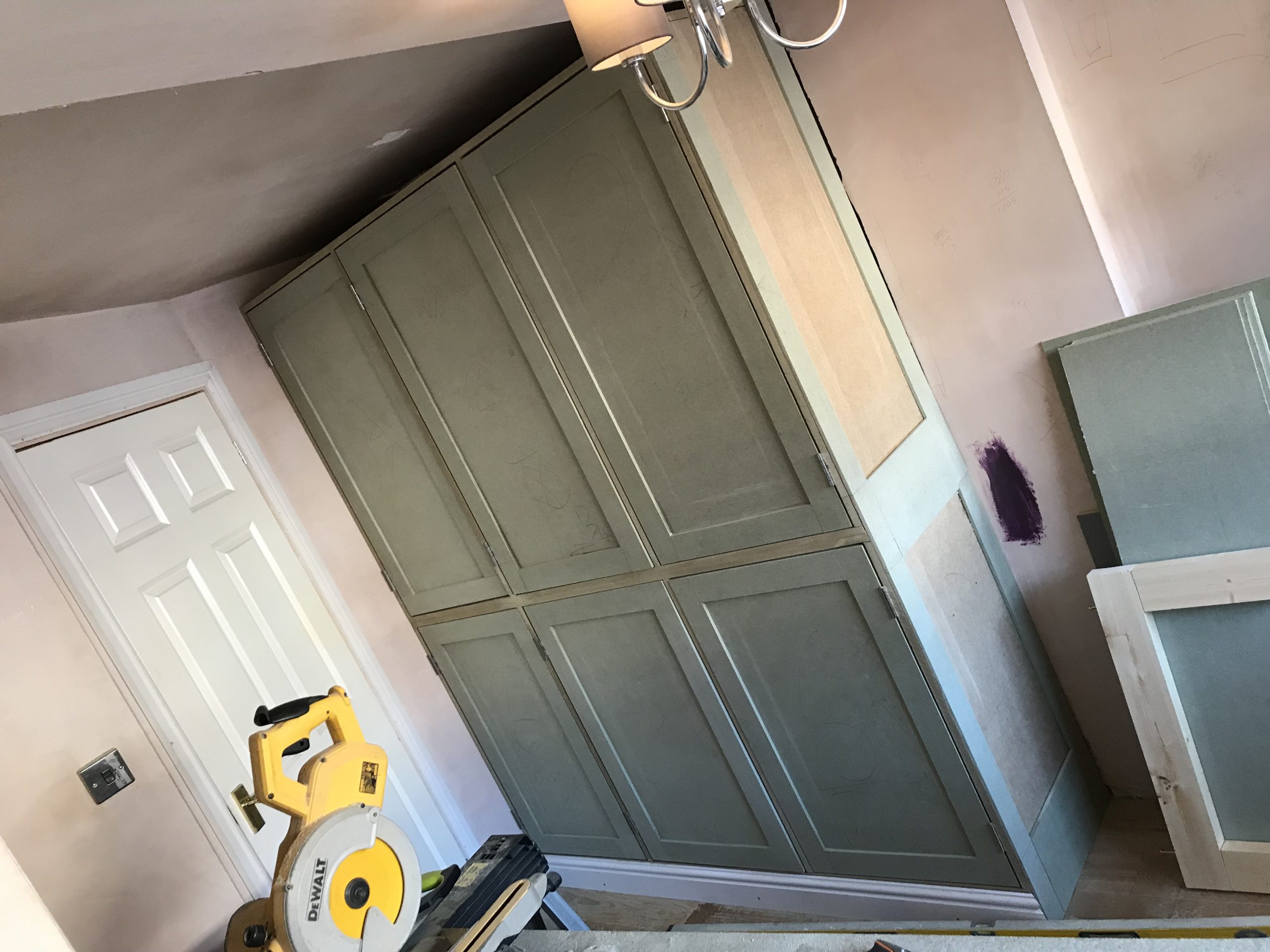 custom built shaker wardrobes being installed in a garage conversion